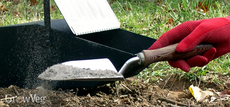 https://gardenplannerwebsites.azureedge.net/blog/spreading-ash-on-garden-soil-2x.jpg